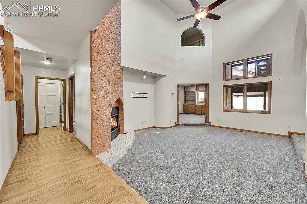 Image 15 of 30: Unfurnished living room featuring a fireplace, light wood-style flooring, c