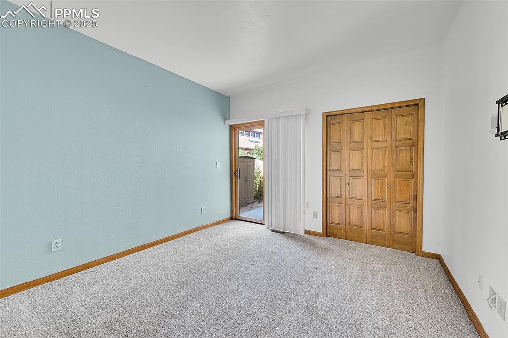 Image 17 of 30: Unfurnished bedroom featuring access to exterior, carpet flooring, and a cl
