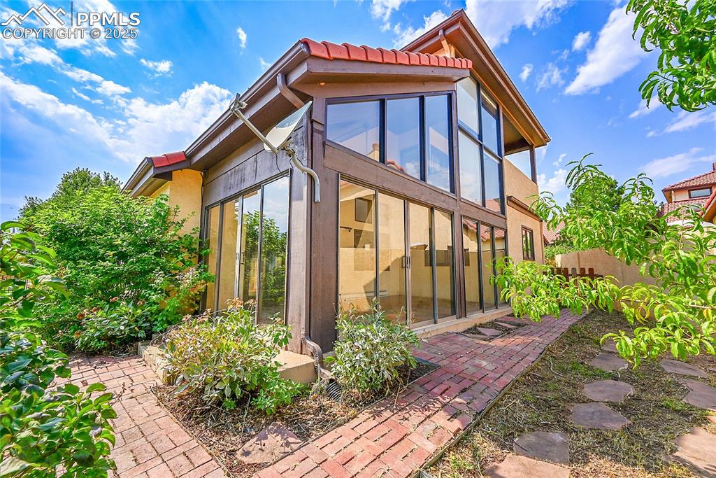 Image 2 of 30: View of property exterior with stucco siding and a tile roof