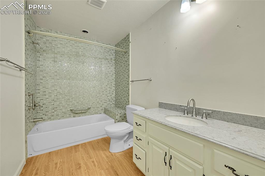 Image 20 of 30: Full bath featuring washtub / shower combination, light wood-type flooring,