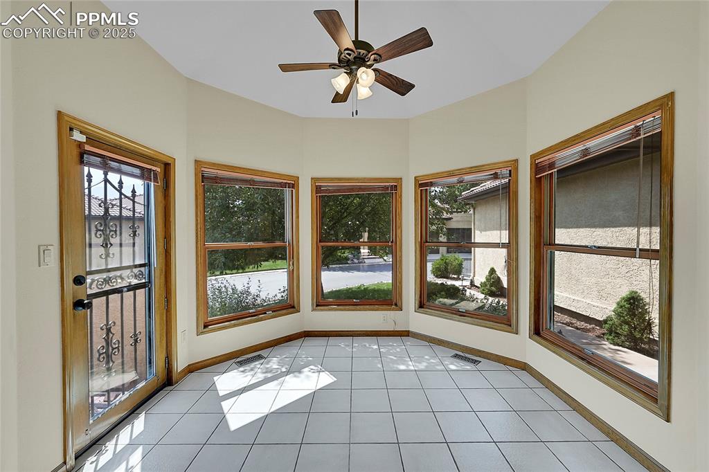 Image 9 of 30: Unfurnished sunroom with tile patterned floors and baseboards