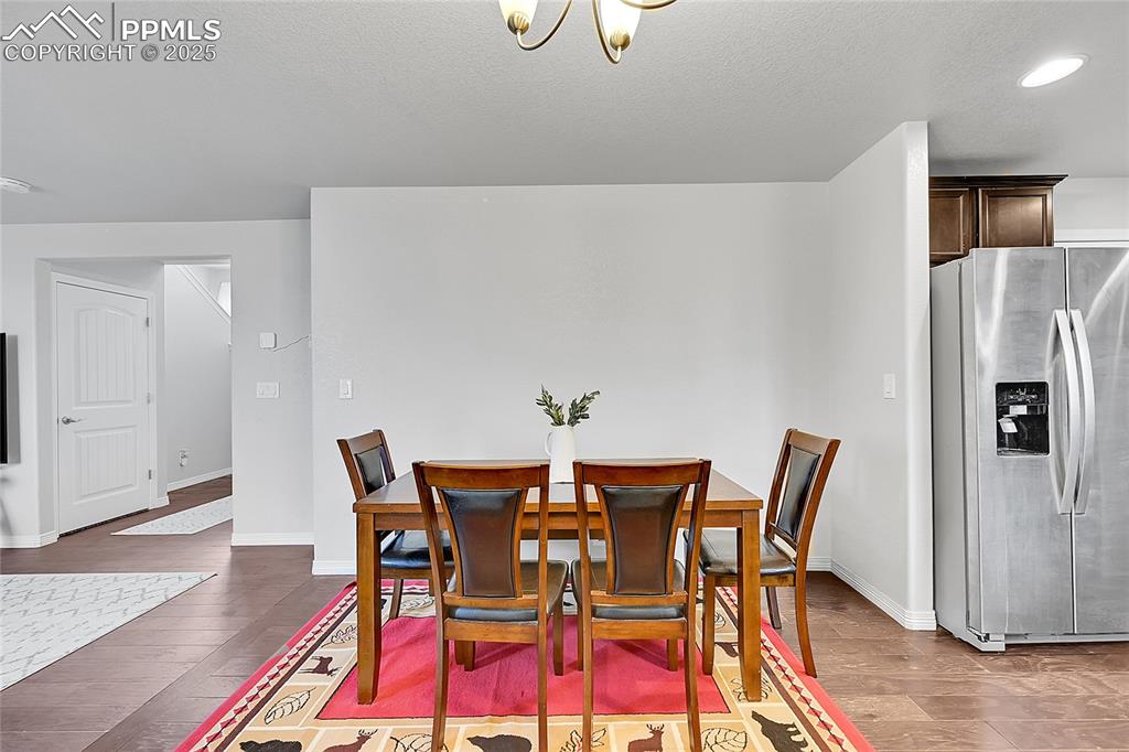 Image 10 of 29: Dining area with baseboards, recessed lighting, a textured ceiling, and woo