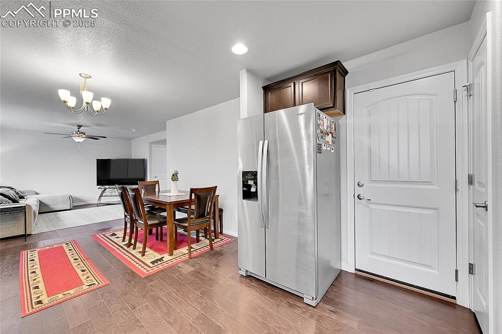 Image 15 of 29: Kitchen with stainless steel fridge, recessed lighting, wood finished floor
