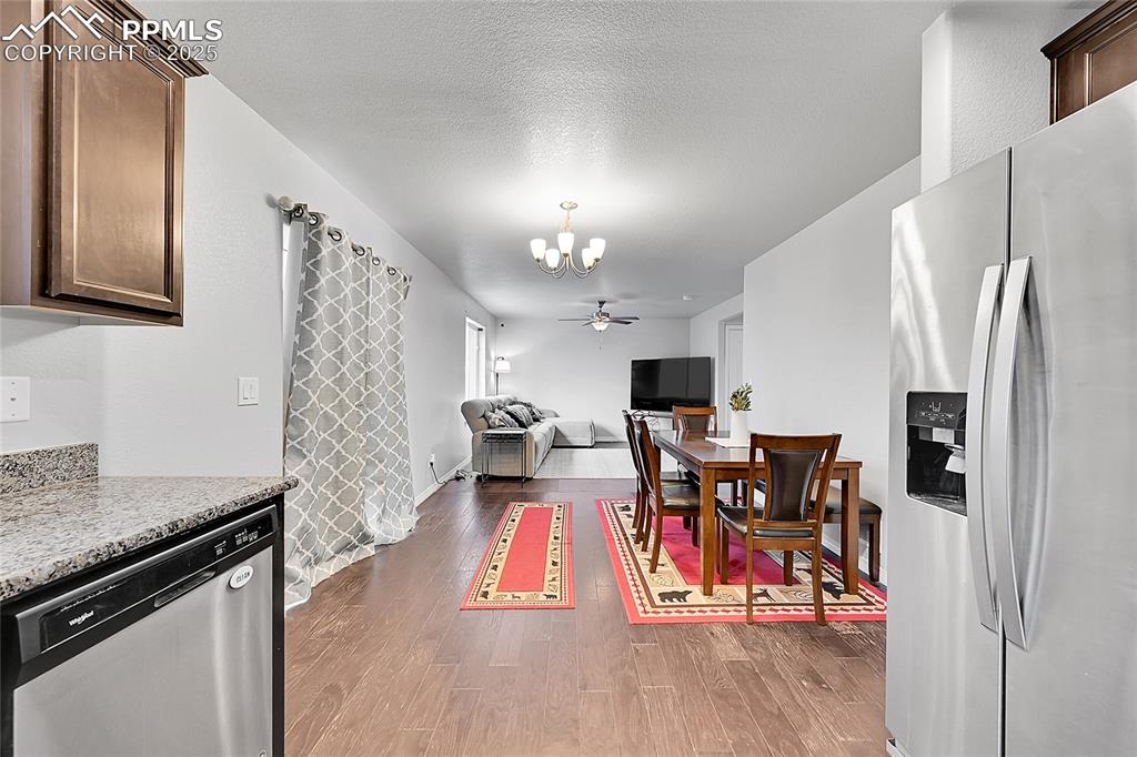 Image 16 of 29: Dining space with an inviting chandelier, baseboards, and dark wood-style f