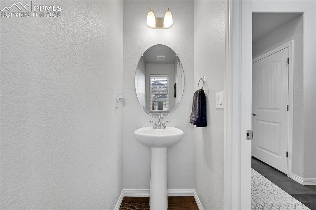 Image 17 of 29: Bathroom with baseboards and a textured wall