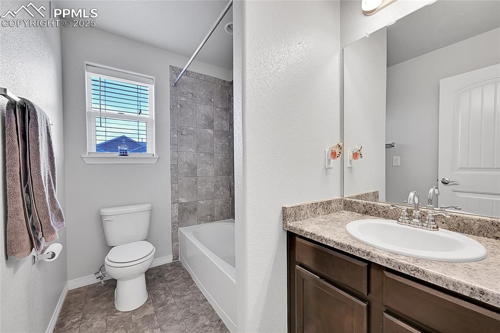 Image 26 of 29: Bathroom featuring toilet, baseboards, shower / bath combination, and vanit