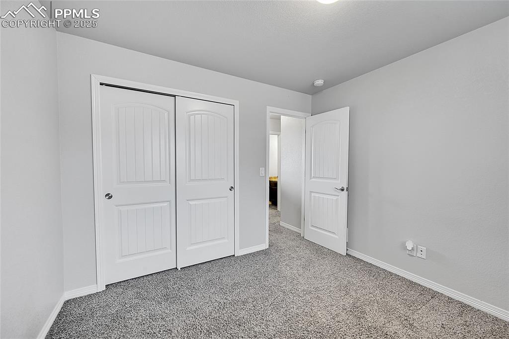 Image 28 of 29: Unfurnished bedroom with a closet, baseboards, and carpet flooring