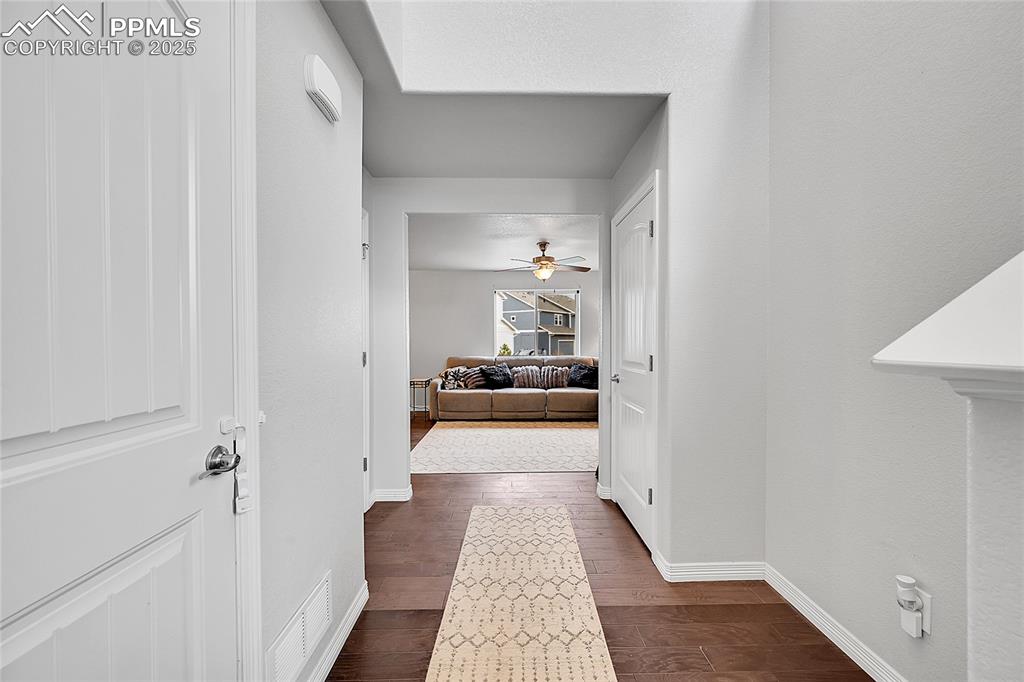 Image 4 of 29: Corridor featuring visible vents, baseboards, and dark wood-style floors