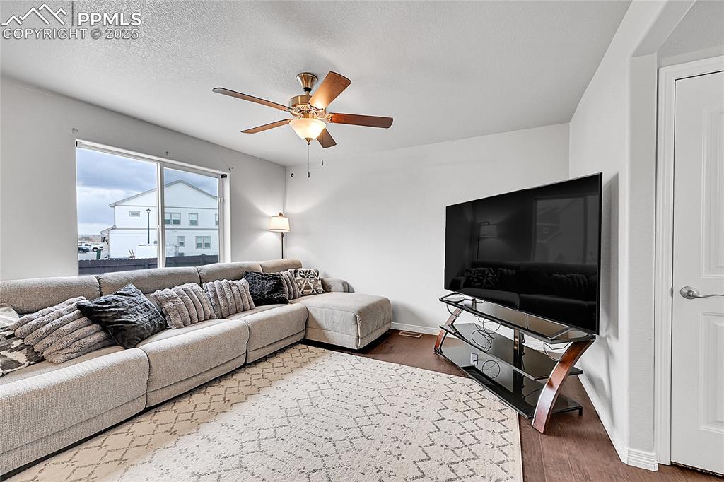 Image 6 of 29: Living room featuring baseboards, ceiling fan, and wood finished floors