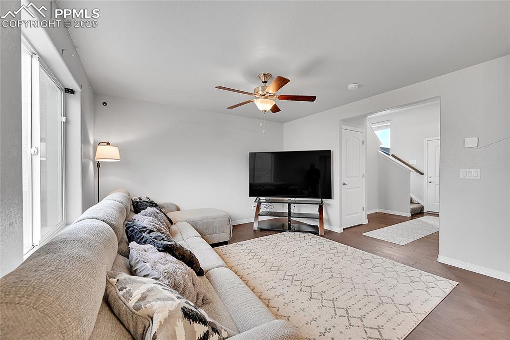 Image 7 of 29: Living area featuring baseboards, a ceiling fan, dark wood finished floors,