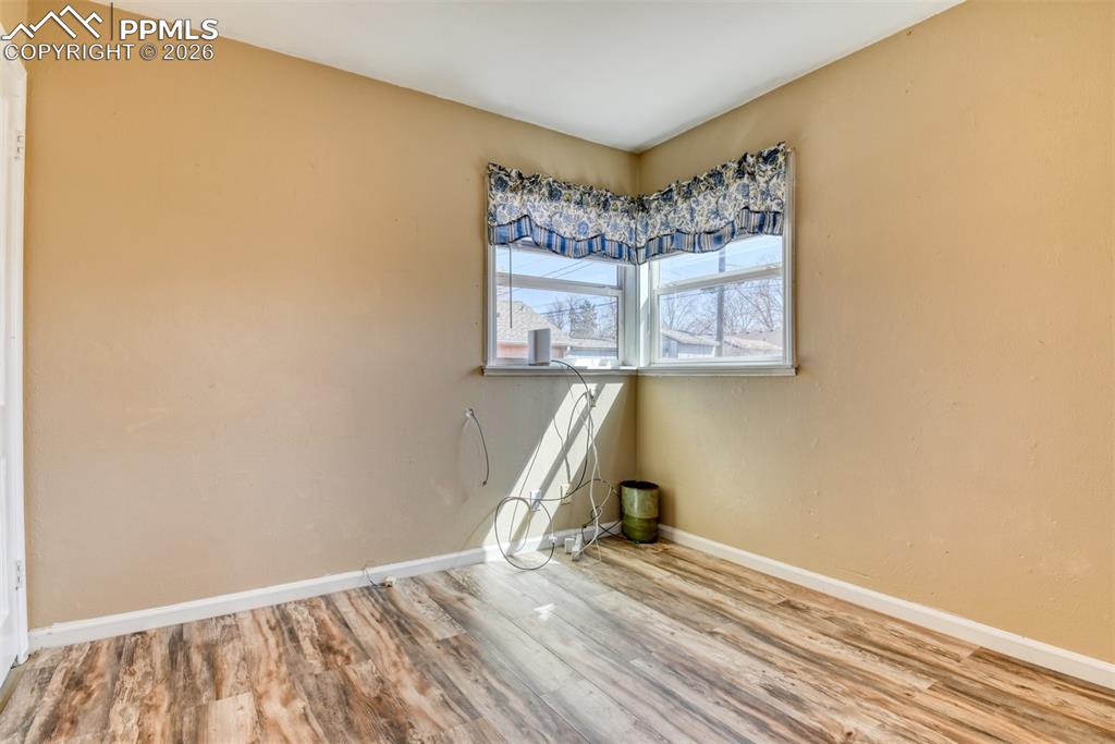 Image 11 of 47: Unfurnished room featuring baseboards and wood finished floors