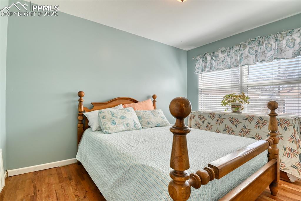 Image 18 of 47: Bedroom with wood finished floors and baseboards