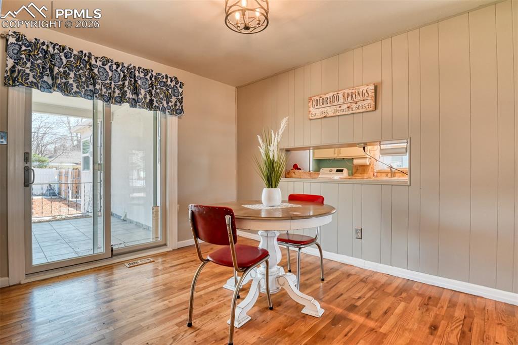 Image 6 of 47: Dining space with wood finished floors, baseboards, and visible vents
