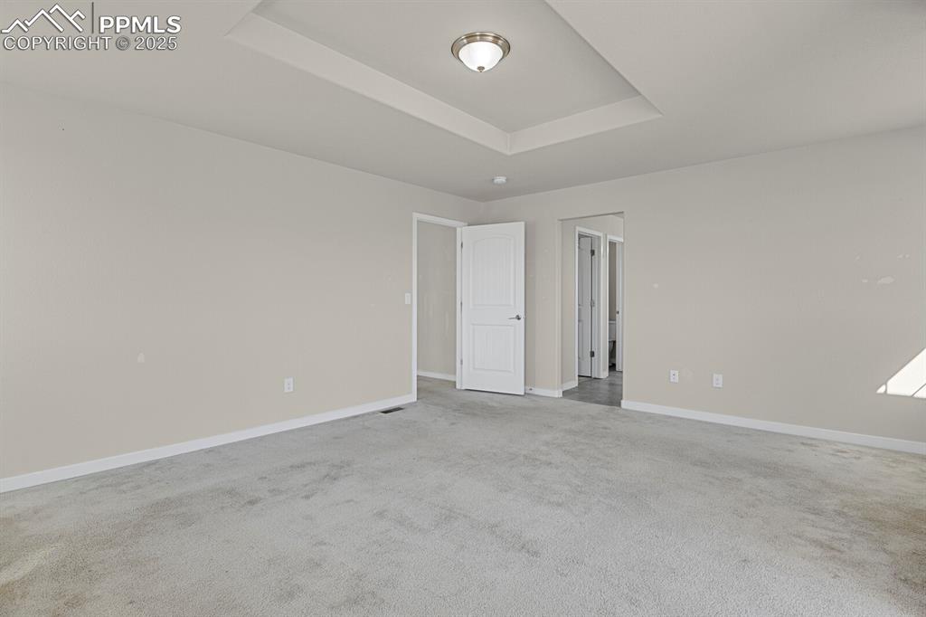 Image 17 of 31: Empty room with a raised ceiling and light carpet