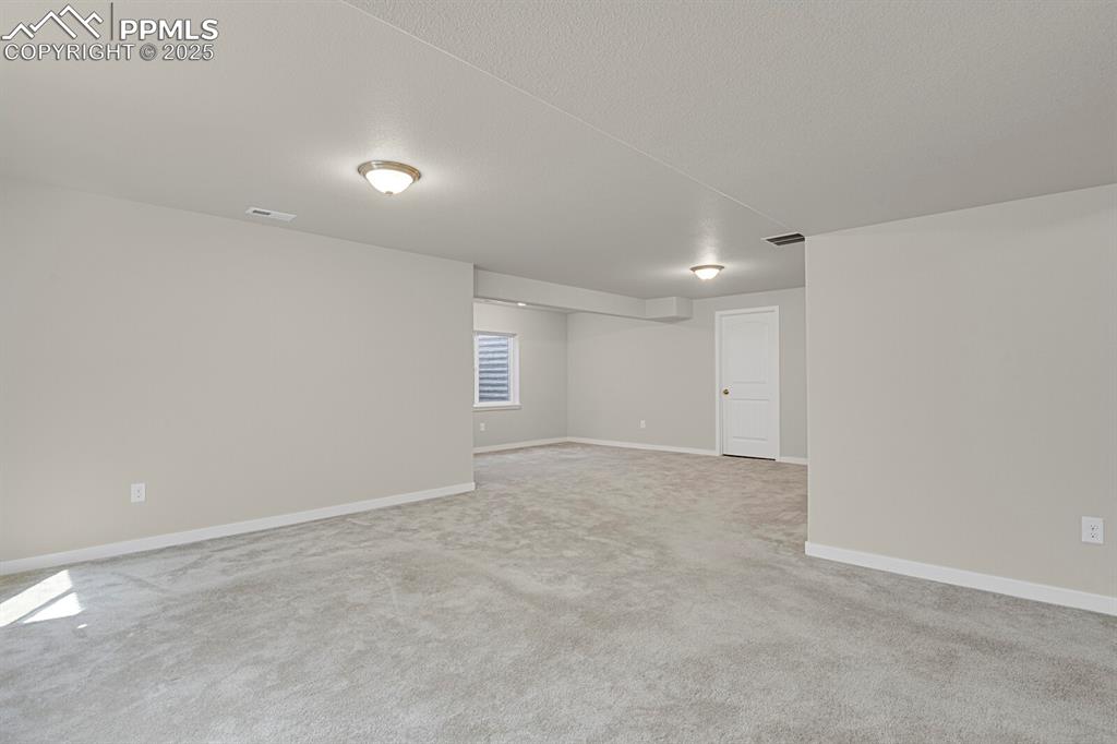 Image 25 of 31: Empty room featuring baseboards and light colored carpet