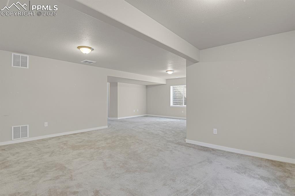 Image 26 of 31: Unfurnished room featuring a textured ceiling and light carpet