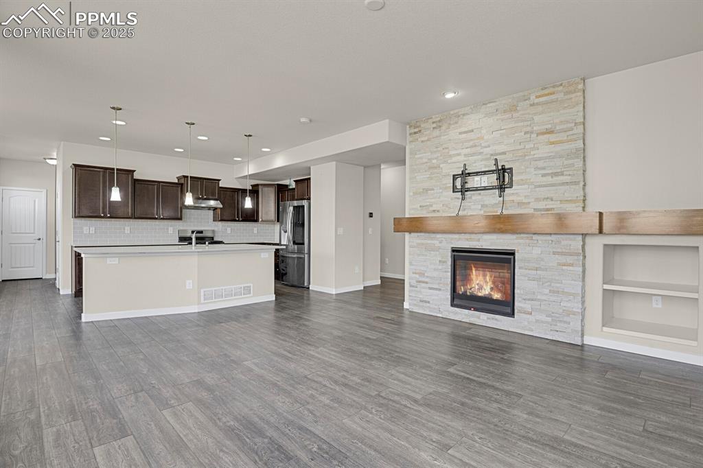 Image 7 of 31: Kitchen featuring open floor plan, light countertops, hanging light fixture
