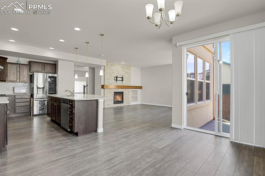 Image 9 of 31: Kitchen featuring hanging light fixtures, dark brown cabinets, stainless st