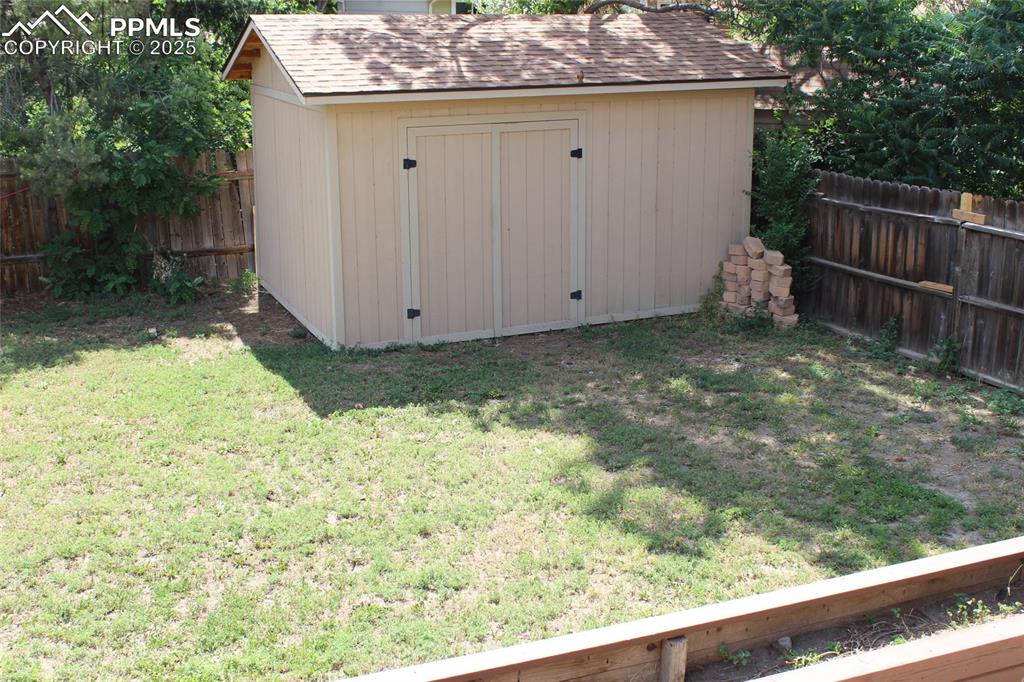 Image 22 of 25: View of shed with a fenced backyard