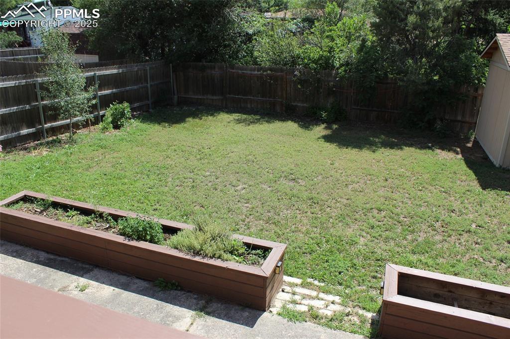 Image 23 of 25: Fenced backyard with a garden