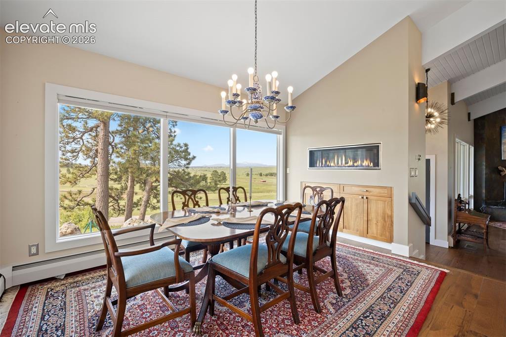Image 11 of 36: Bright breakfast nook with linear fireplace and walk-out to the covered pat