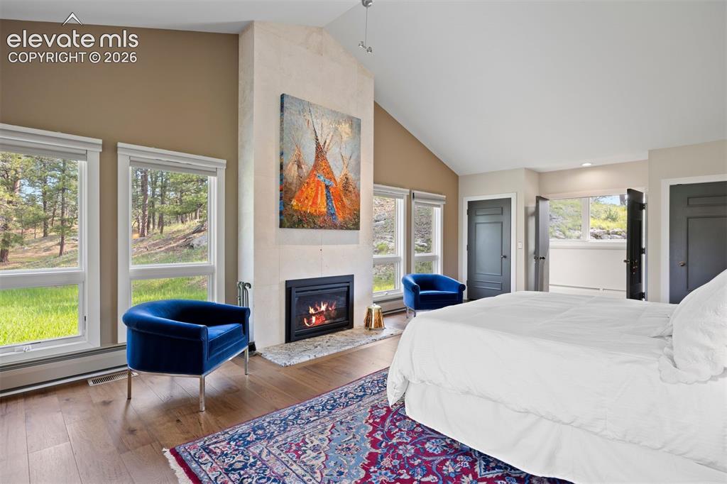 Image 14 of 36: Floor-to-ceiling stone tile accents the fireplace and wall-to-wall windows 