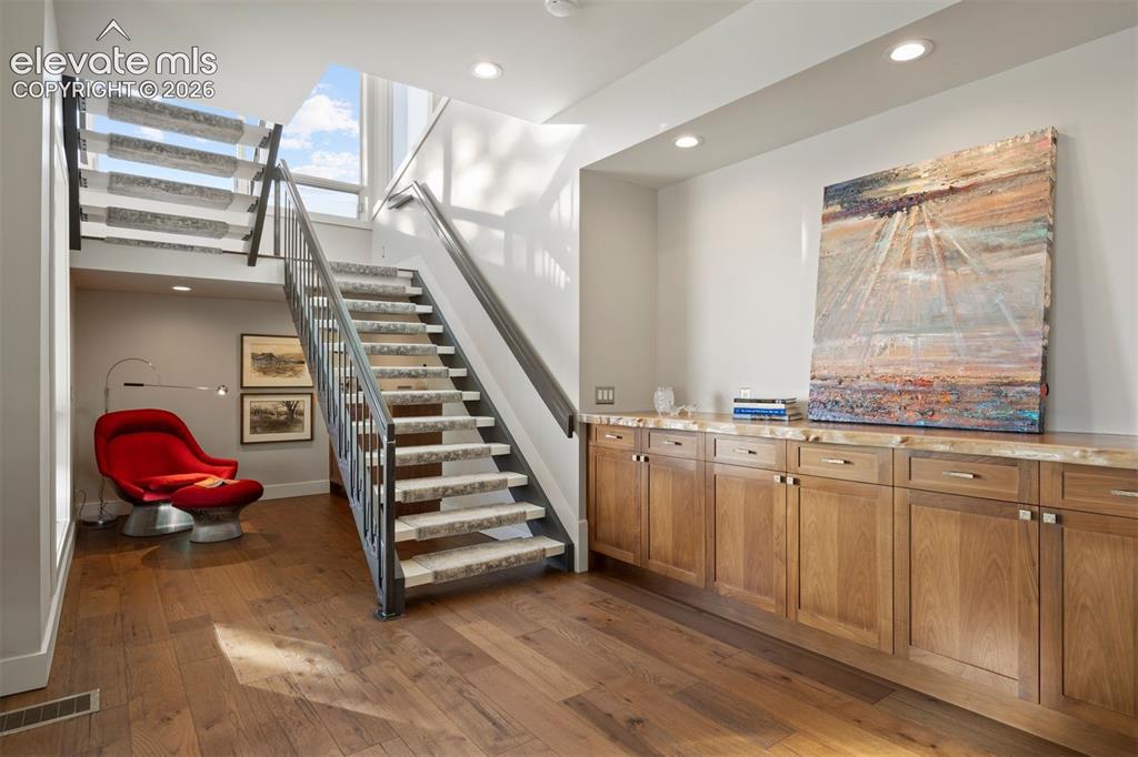 Image 19 of 36: Open riser staircase with under-stair reading nook.