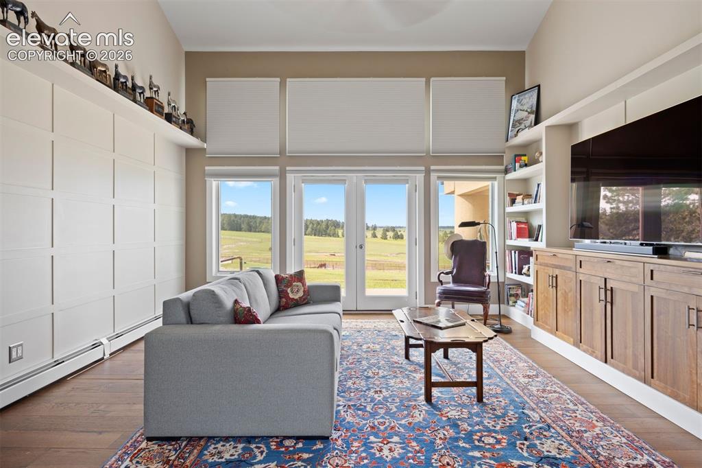 Image 23 of 36: Main level den overlooking the pasture and walk-out to the front patio, boa