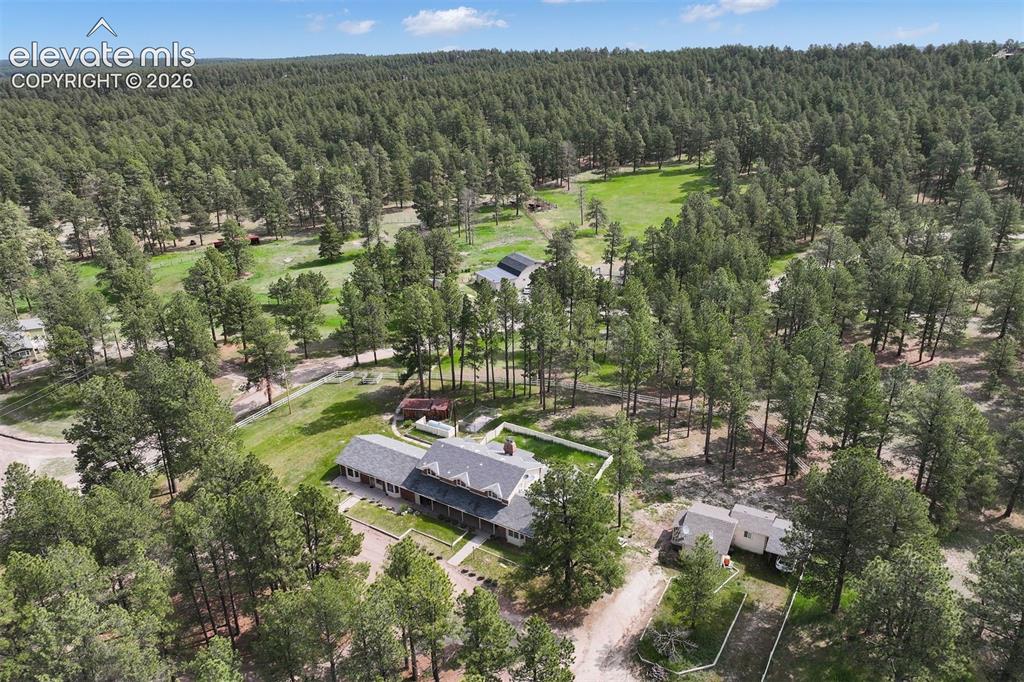 Image 32 of 36: Aerial view of the guest house, grounds, and additional buildings.