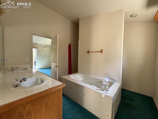 Image 13 of 19: Bathroom featuring a whirlpool tub and double vanity
