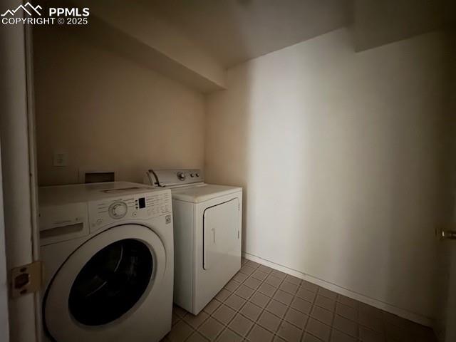Image 14 of 19: Washroom featuring washing machine and dryer and dark tile patterned floori