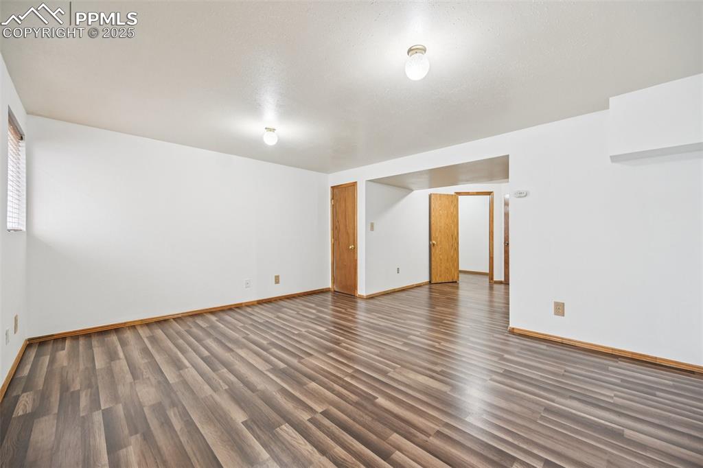 Image 15 of 28: Spare room featuring dark wood-type flooring