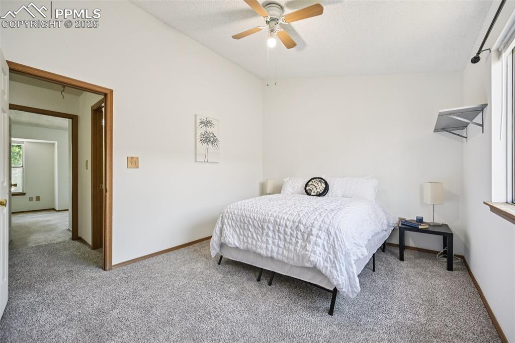 Image 18 of 28: Carpeted bedroom featuring ceiling fan and a textured ceiling