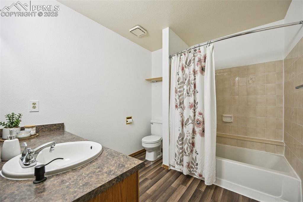 Image 20 of 28: Full bathroom featuring shower / tub combo, dark wood-style floors, and van