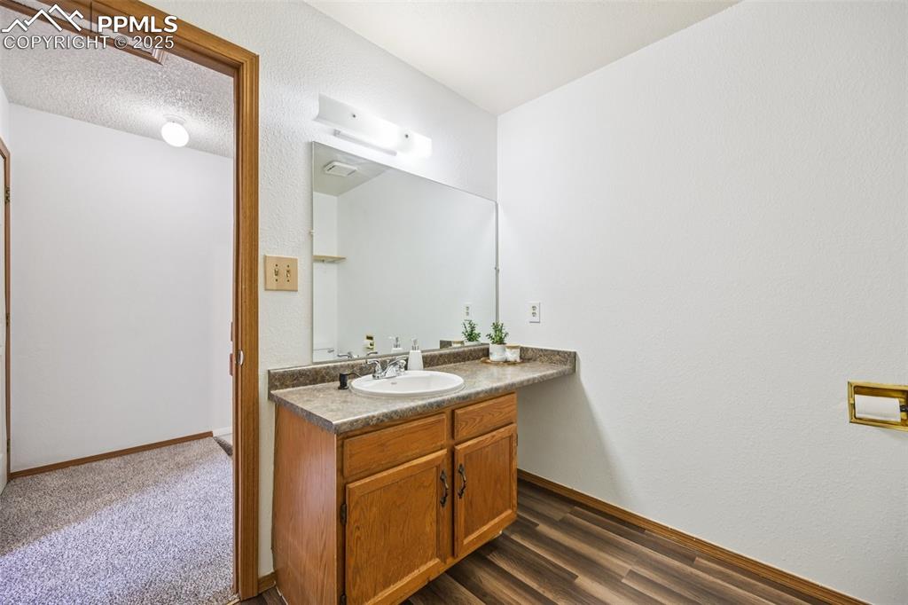 Image 21 of 28: Bathroom featuring vanity and dark wood-type flooring