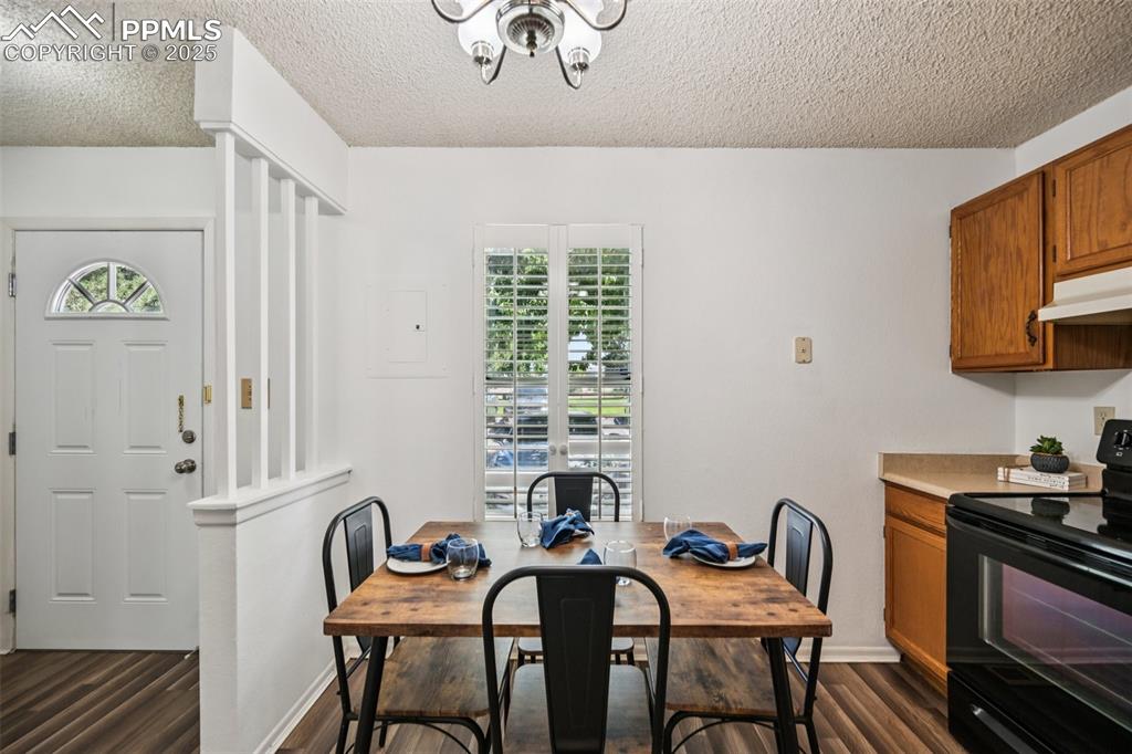Image 7 of 28: Dining room with healthy amount of natural light, a textured ceiling, dark 