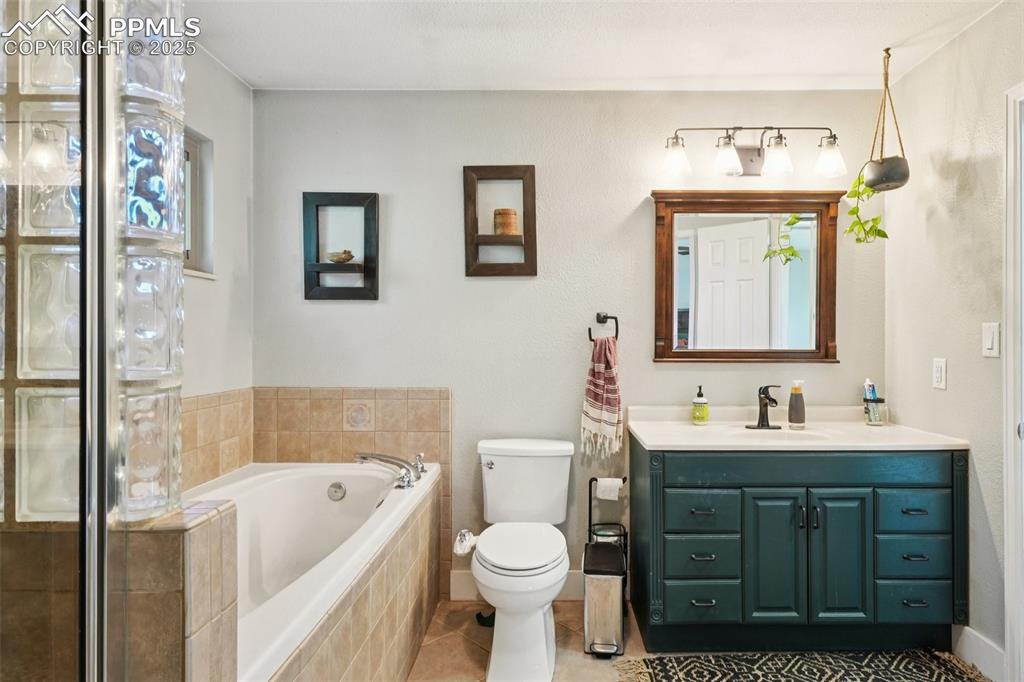 Image 18 of 38: Primary 4 piece bathroom with soaking tub and stand in shower
