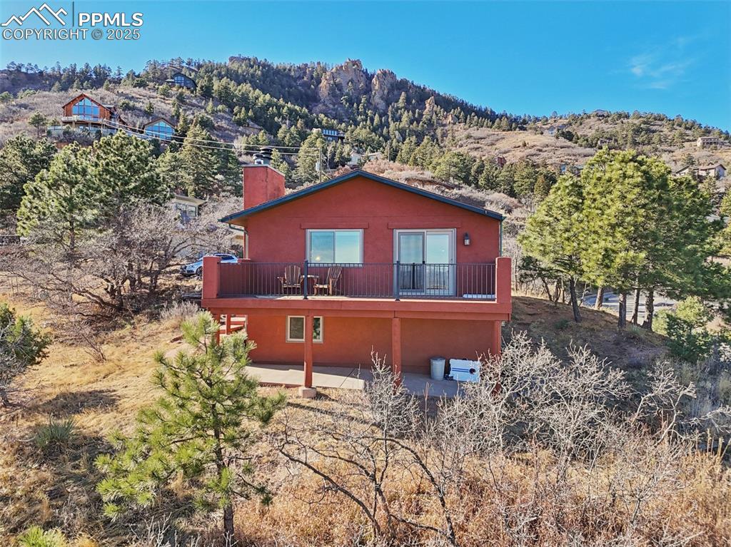 Image 34 of 38: Just look at the spacious back deck and patio surrounded by the foothills!