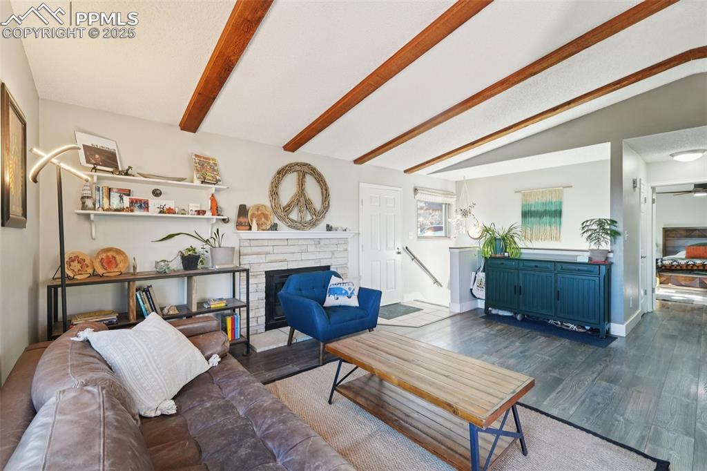 Image 4 of 38: Living room with wood burning fireplace and LVP flooring all encompassed by