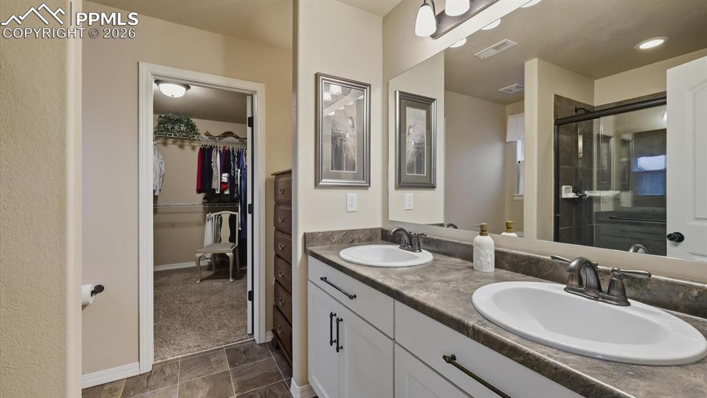 Image 26 of 50: The Primary Bathroom has a dual sink vanity and mirror.