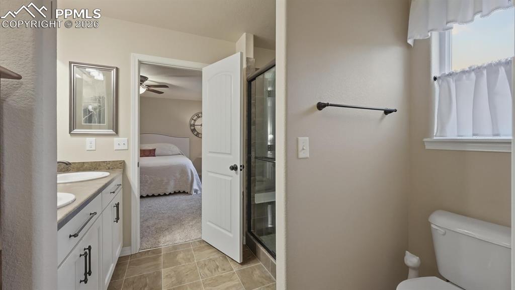 Image 29 of 50: View into the Primary Bedroom from the Primary Bathroom.