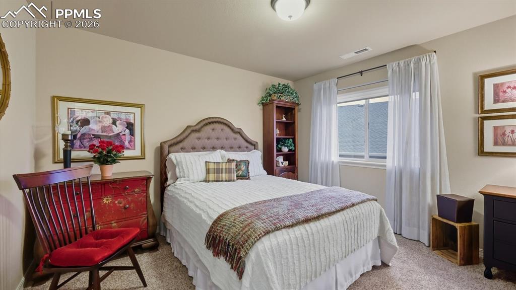 Image 31 of 50: Upper Level Bedroom #2 with neutral carpet.