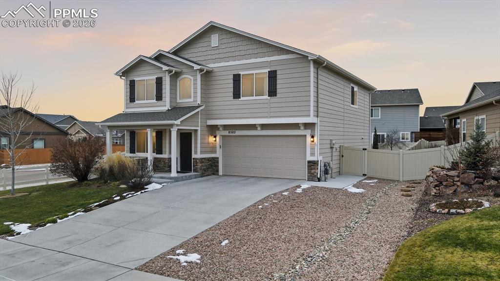 Image 5 of 50: Rock side yard and concrete walkway to the backyard.