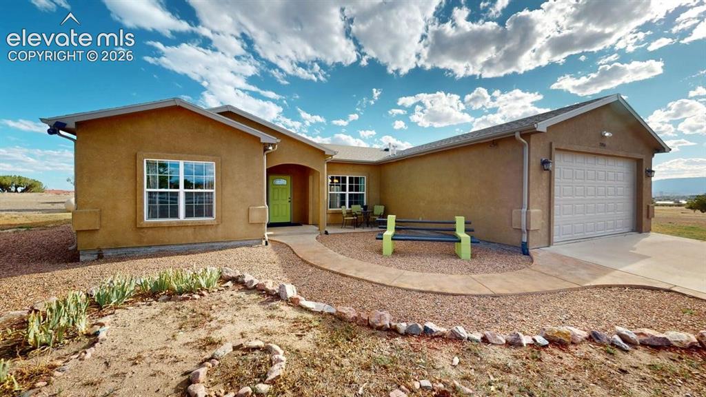 Image 1 of 50: Stucco exterior with an attached garage, arched entry, and a front pathway