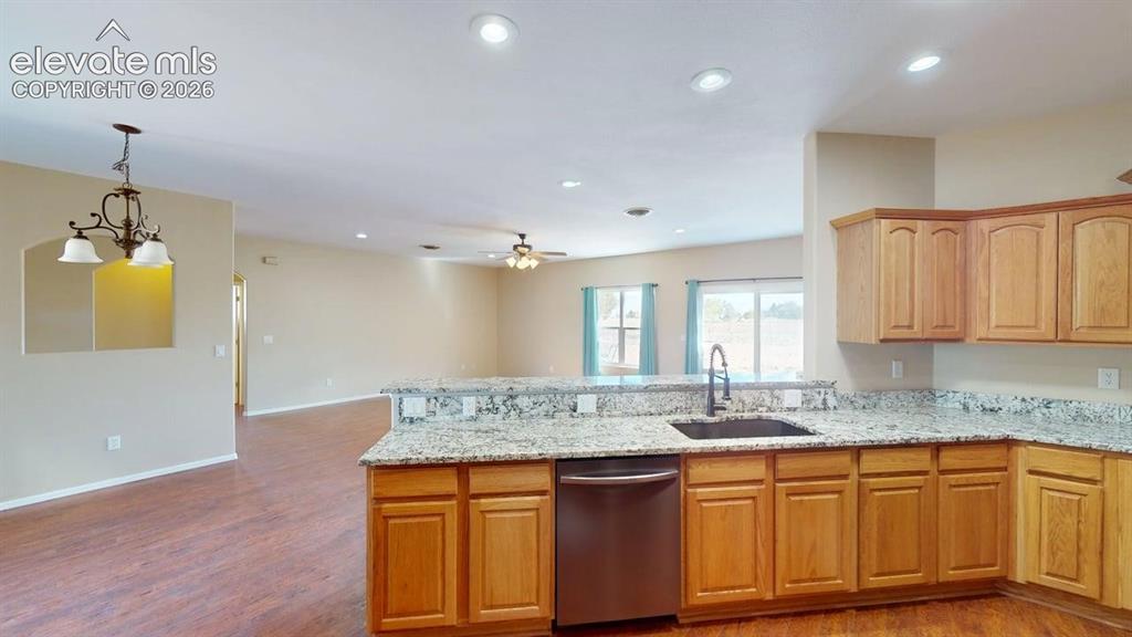 Image 10 of 50: Kitchen with granite countertops, wood-finish cabinetry, stainless steel di