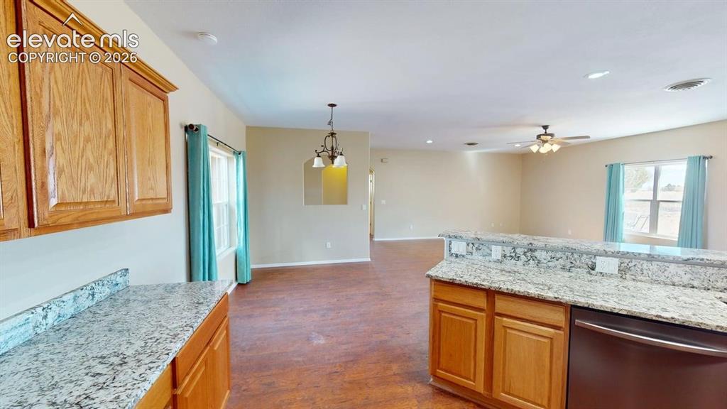 Image 11 of 50: Wood-finish flooring throughout, with light-toned wall paint, and kitchen f