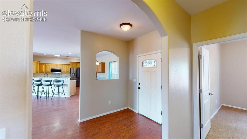 Image 12 of 50: Entryway with wood-finish flooring and an arched doorway