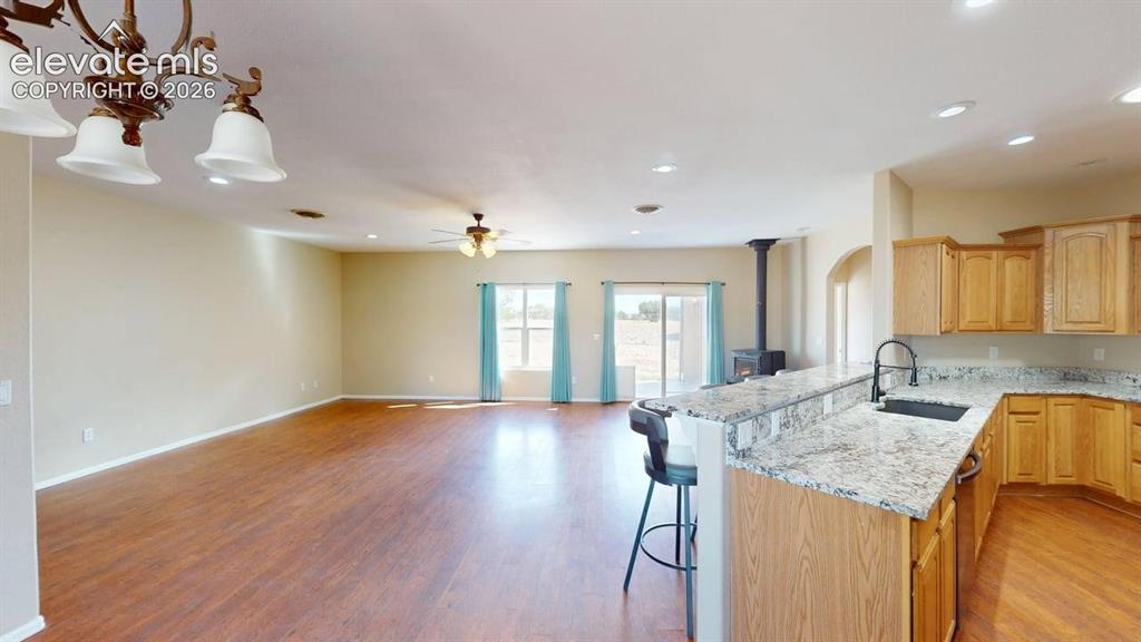 Image 15 of 50: Open concept living area featuring wood-finish flooring, recessed lighting,