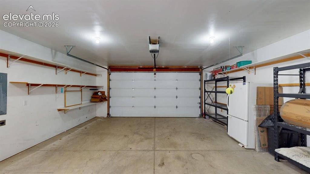 Image 17 of 50: Garage with overhead lighting and a single overhead door