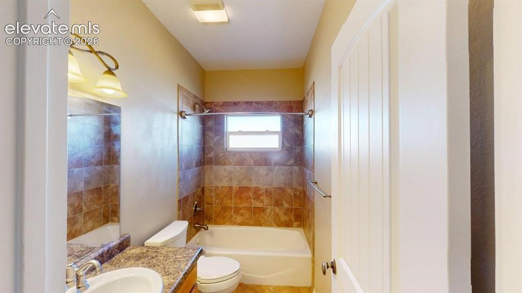 Image 20 of 50: Bathroom featuring a single vanity with an integral sink, a tiled tub/showe